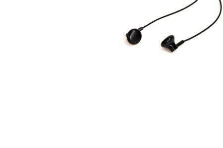 little black earbuds in different positions lying on a white background