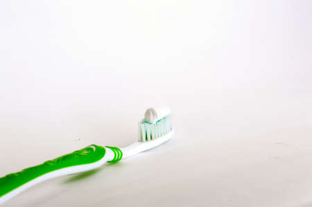 green toothbrush with toothpaste on white backgroundの写真素材