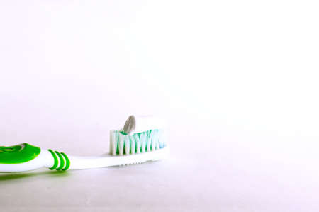 green toothbrush with toothpaste on white backgroundの写真素材