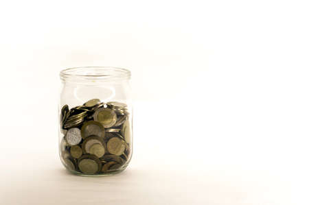 coin money in glass jar, white background in different positionsの写真素材
