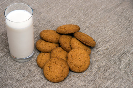 glass of milk and oatmeal cookies on a gray concrete background. Top view