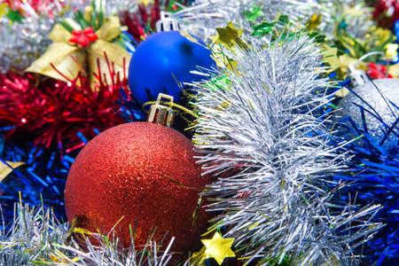 Christmas balls of different colors are on a multicolored tinselの写真素材
