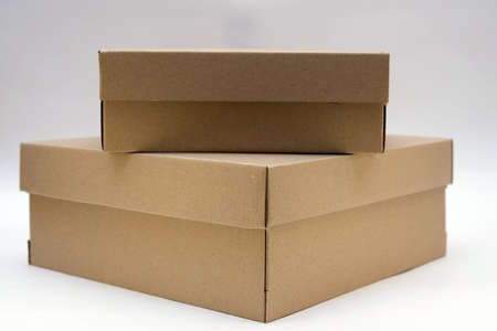 two cardboard boxes lie one on the other on a white backgroundの写真素材