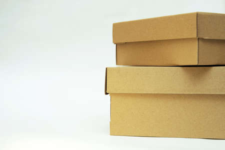 two cardboard boxes lie one on the other on a white backgroundの写真素材