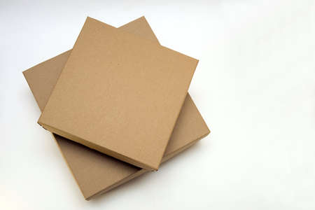 two cardboard boxes lie one on the other on a white backgroundの写真素材