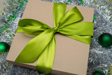 Close - up simple Christmas gift with green ribbon, cardboard box, new year gift close-upの写真素材