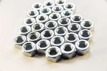 Pile of metal screw-nuts on a white backgroundの写真素材