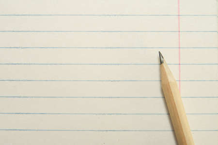 One Sharpened Yellow Pencil on a Diagonal with a Paper Backgroundの写真素材