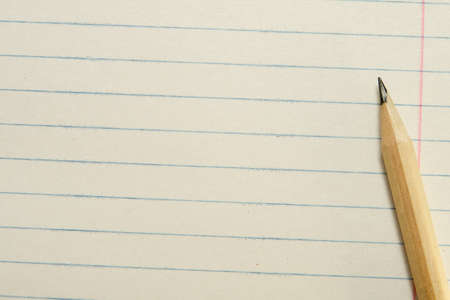 One Sharpened Yellow Pencil on a Diagonal with a Paper Backgroundの写真素材
