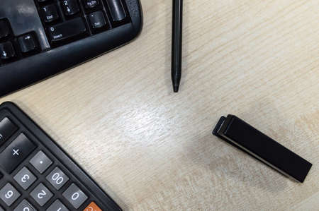 Office wooden Desk with stationery accessories, keyboard, stapler, calculator and pen, close up. office workplace,の写真素材