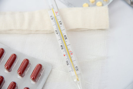 pills and thermometer isolated on white background
