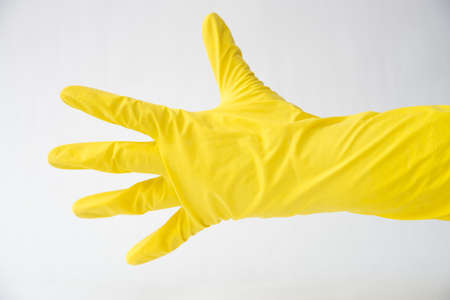 hand in yellow glove open palm, white background, fingers in different directions,の写真素材