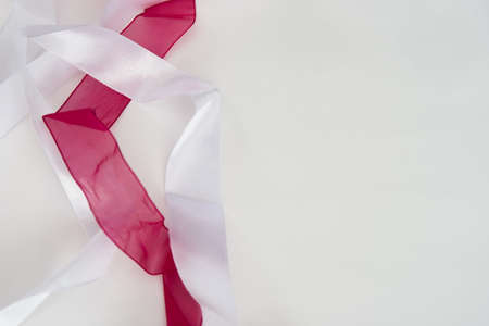 two satin ribbons of red and white, on a white background, close-up, mixed,の写真素材