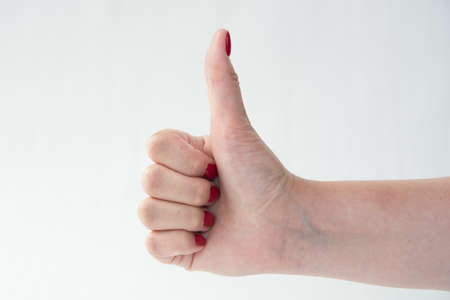 close-up of woman's hand with red nails pointing index finger on white backgroundの写真素材