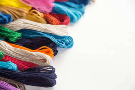 multi-colored thread floss lie on a white background from the bottom up perspective, thread for cross stitchの写真素材