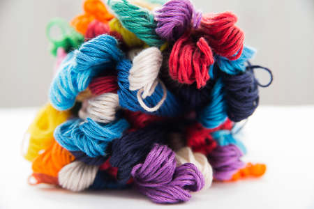 multi-colored thread floss lie on a white top view with a place for the inscription, colored thread for cross stitchの写真素材