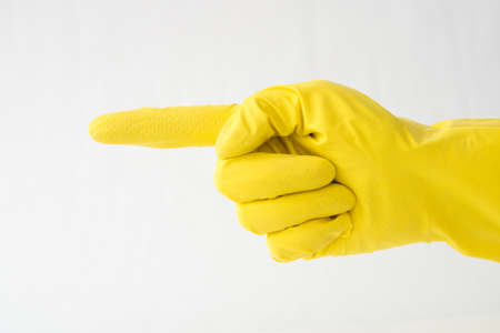 hand in yellow glove, finger gesture forward, direction indicationの写真素材