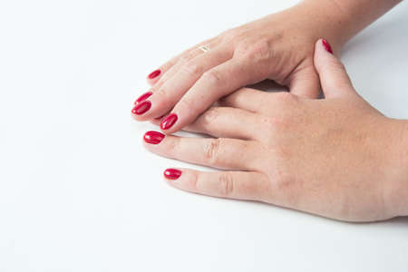 Beautiful womans hands on light background. Care about hand. Redl manicure, clean skin. Bright nails with polish on white backgroundの写真素材