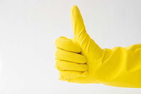 hands in yellow gloves, thumb up, white background, sign that all is well,の写真素材