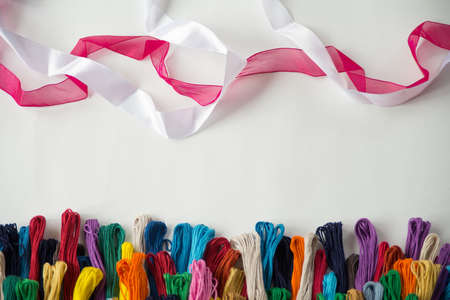 colored embroidery floss and white and red ribbon, top view, white background, Flatleyの写真素材