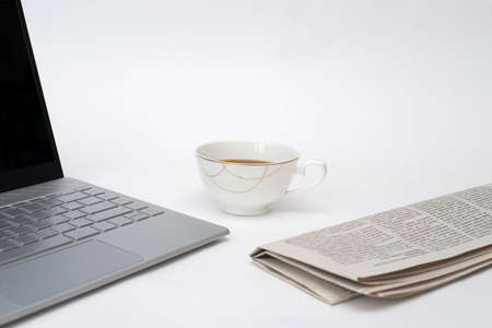 laptop, fresh newspaper and hot coffee on white background, white Desk of office worker, financial consultantのeditorial素材
