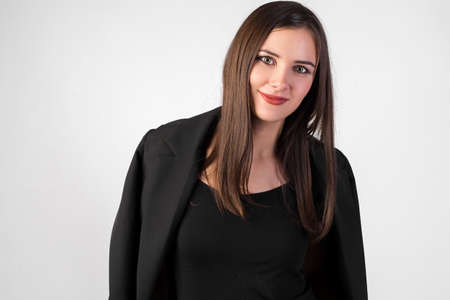portrait of a young beautiful girl on a white background, black jacket thrown over her shoulders, straight dark hair, sexy look,の写真素材