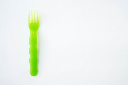 plastic fork green white background top view