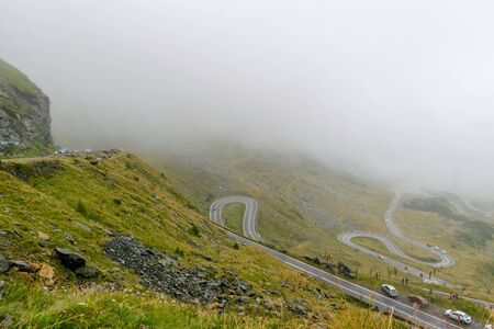 The road that crosses the Fagaras mountains seen from above among the fog, Transfagarasan, Romaniaの写真素材