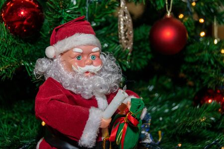 Santa Claus sitting close to the Christmas treeの写真素材