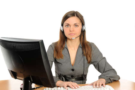   female customer service representative in headset in front of her desktop computerの写真素材