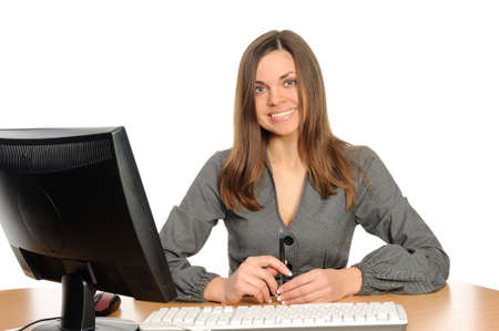 Business woman portrait smiling in front of her desktop computerの写真素材