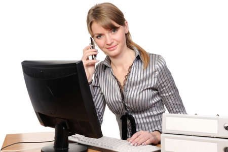 Business woman portrait smiling in front of her desktop computerの写真素材