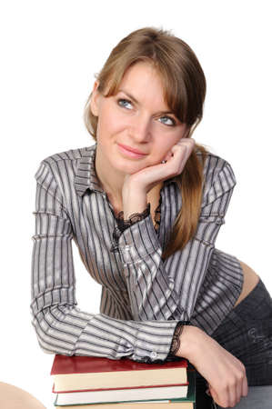  Thinking young girl with long hair and books on a tableの写真素材