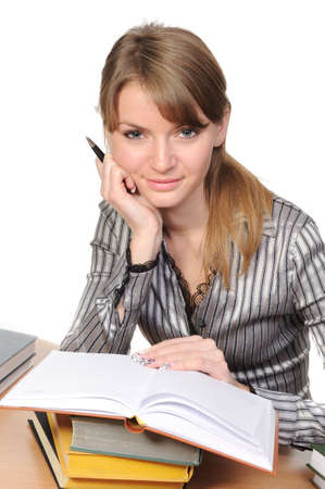 Beautiful woman with long hair sits at a table with the bookの写真素材