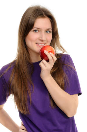 Portrait of cheerful young woman holding a red apple and smiling isolated against white background の写真素材
