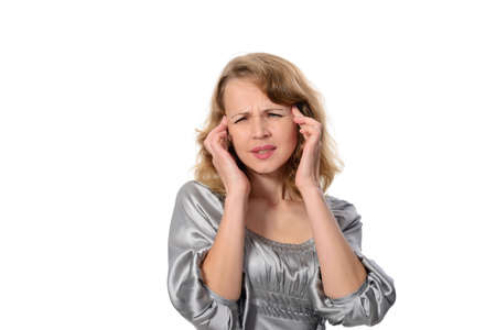 Woman suffering from a headache grimacing and holding her hands to her ears to relieve the throbbing, closeup studio head portrait on white の写真素材