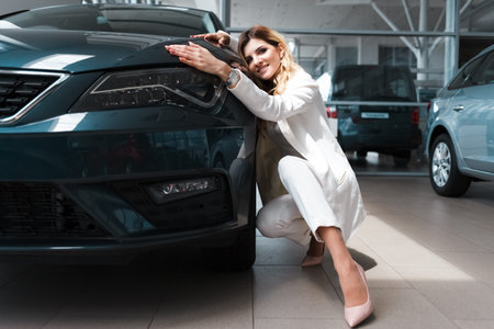 Pretty business lady hugs her new car. Woman buys a car