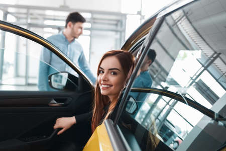 Young couple in auto dealership chooses a carの写真素材