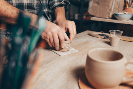 Process of creating a clay cup in pottery workshop