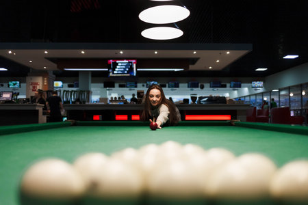 Woman aiming at balls in billiards