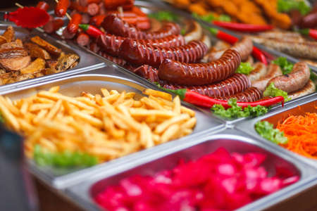 Various food at the annual christmas fair. Fried sausages, french fries and other tasty foodの写真素材