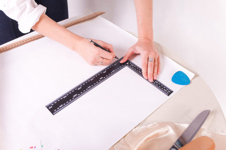 The seamstress makes a pattern for the future product. Sewing workshop. Woman engages in her...