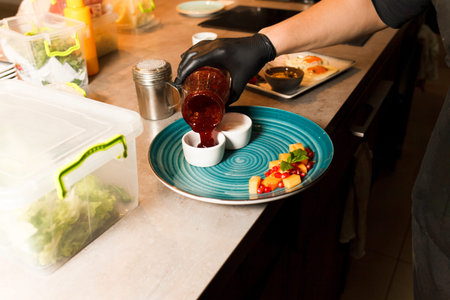 Chef preparing home made cottage cheese fried in a pan and served with sauces and fruit