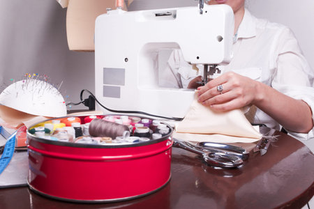 close up shot of a woman's hands, who is engaged in sewing in the home