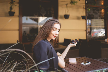 Beautiful lonely lady at a cafe table looks thoughtfully