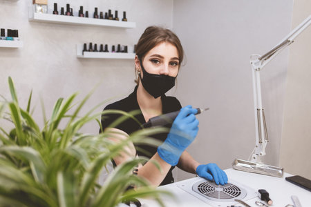 Young beautiful manicurist waiting for clients at beauty salon