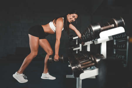 Athletic young woman doing dumbbell exerciseの写真素材