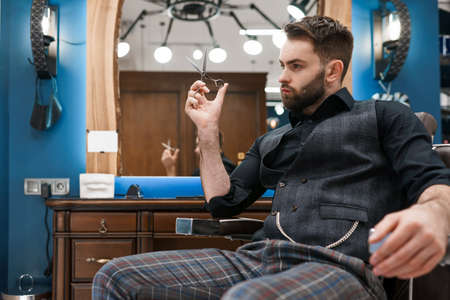 Handsome male hairdresser with scissors in handsの写真素材