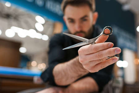 Handsome male hairdresser with scissors in handsの写真素材