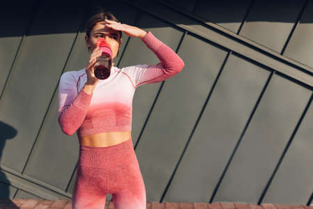 Sporty girl drinking water from the bottleの写真素材